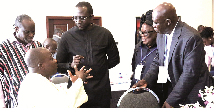  Mr Mahama Ayariga (seated) in a discussion with some of the participants in the workshop. They include Mr Moses Asaga (left) and Mr Kingsley Kwame Awuah-Darko  (middle), the Chief Executive of TOR, and Mr Ben Dagadu (2nd right)