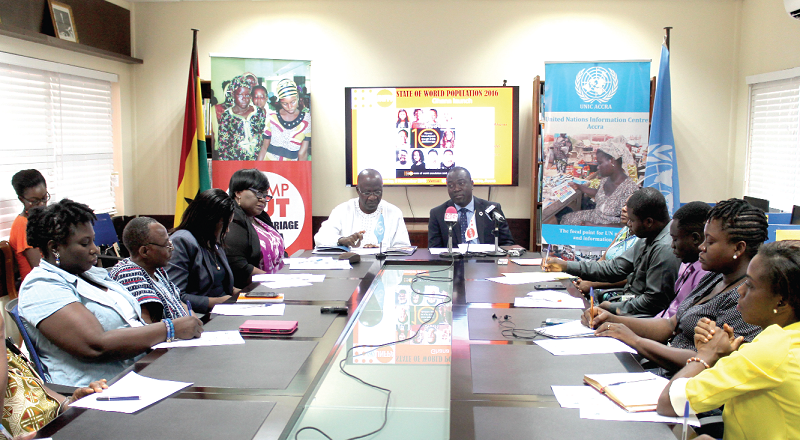Dr Babatunde Ahonsi (with microphone) addressing participants in the launch of the 2016 State of the World Population Report. With him is Dr William Ahadzie (left), Chairman of the National Population Council.