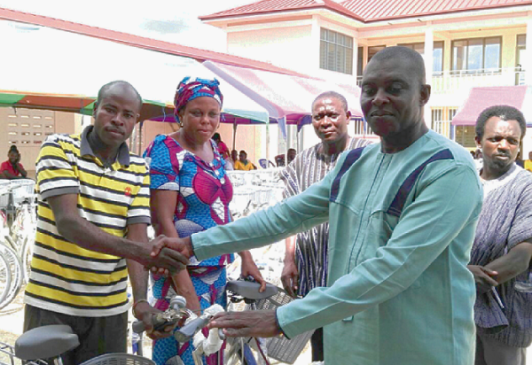  Alhaji Mumuni Isaac Dramani (right) presenting a bicycle to one of the facilitators
