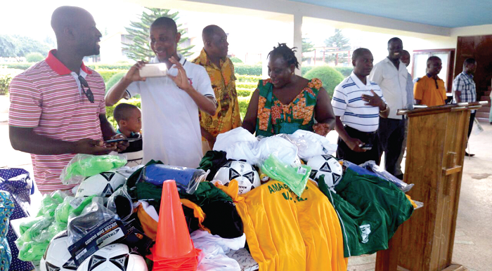 Some of the old students standing behind the items donated