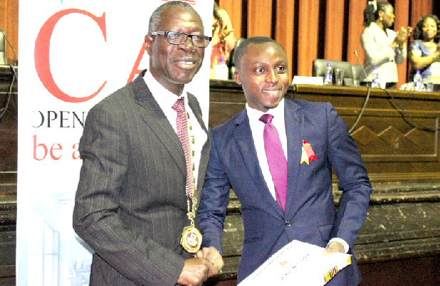 Mr Daniel Tamatey Hogah (right) being honoured by the president and  chairman of the institute as the overall best candidate for the 2016-year batch. Picture: BENEDICT OBUOBI
