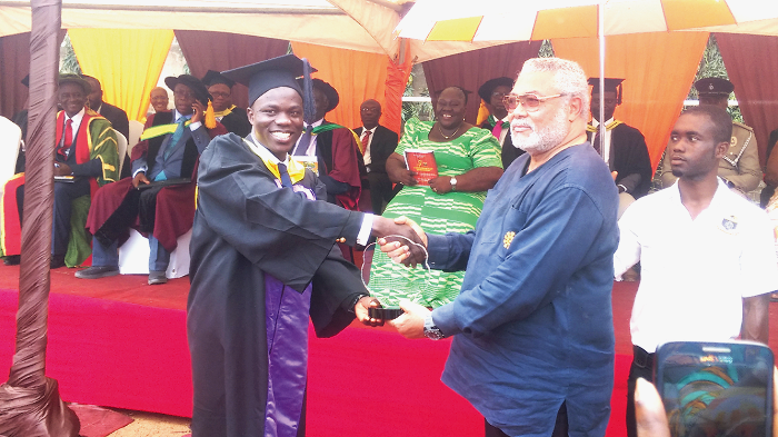 Former President Rawlings (2nd right) handing over the memento to Mr Awuah at the fifth Kaaf Congregation in the Central Region.