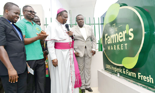  Rt Rev T.B Forson (in cassock) Bishop of the Tema Diocese of the Methodist Church and some dignitaries by the company's plague. INSET: Rt Rev T.B. Forson cutting the tape to officially open the retail outlet