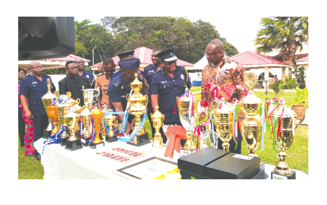  The Minister of the Interior, Mr Prosper Bani (right), with the IGP, Mr John Kudalor (2nd from right), and other dignitaries, inspecting the numerous trophies and medals the Police sports teams had won in their various disciplines