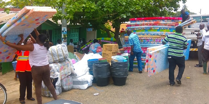 Officials of the Eastern Regional National Disaster Management Organisation (NADMO) distributing relieve items to some of the victims of the flooding in Koforidua