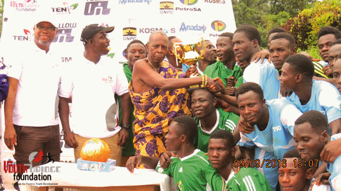   Nana Kwaa Tentenele (in cloth), presenting the Unity Cup to the captain of the Upper Axim team, supporterd by the MCE of Nzema East (second left), Mr James Atta Kakra Baidoe