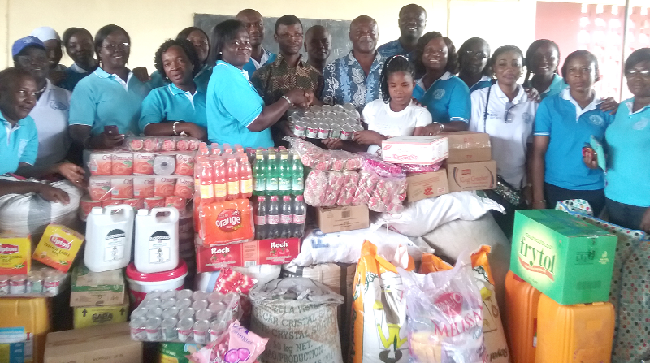 The Ashanti Chairperson of the Ladies Association of the GWCL, Mrs Henrietta Owusu Konadu (left), presenting the items to Mr Modesto Ayiwoli, looking on are members of the association