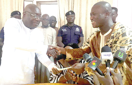 Mr Alhassan Tampuli (right), the CEO of the NPA, presenting a cheque to Dr Kwaku Afriyie, the Western Regional Minister, in support of the gas explosion victims