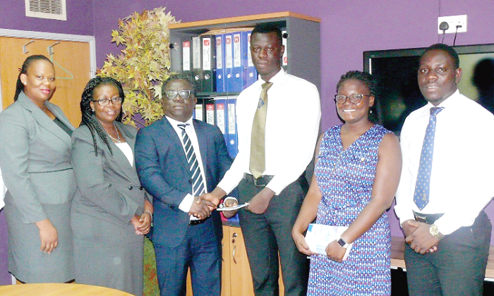 Mr Faris Attrickie (3rd left) joined by other executives of the company to hand over the insurance package to representatives of the students