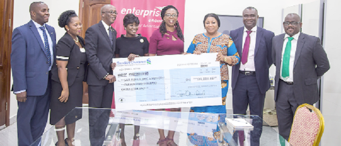 Mr Keli Gadzekpo (3rd left) presenting a dummy cheque to Mrs Rebecca Akufo-Addo (3rd right)