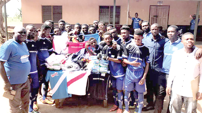 The managing Director of NanaJoy Hotel, Nana Wereko-Ampim Opoku (left) looks on as players of Jachie United FC admire the items