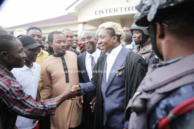 Mr Alex Afenyo Markin, Lawyer for the plaintiff, shaking hands with his supporters after the hearing