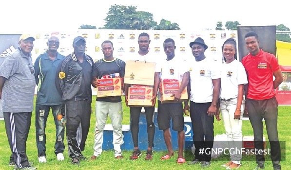 Officials of GNPC, organisers and some athletics legends pose with the men’s 100m winner Desmond Aryee and the two runners-up