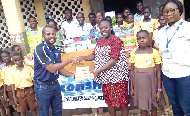  An official of Conship Consolidated Shipping Agencies Limited (left), presenting the materials to the Headmistress ,  Madam Ama Owusua Mensah (right) while some of the teachers, officials of the company and pupils look on