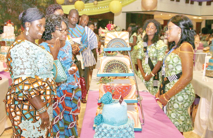 • Mrs Efua Goode Obeng-Kyei (1st left) and some special guests interacting with two members of the graduating class during the cake inspection