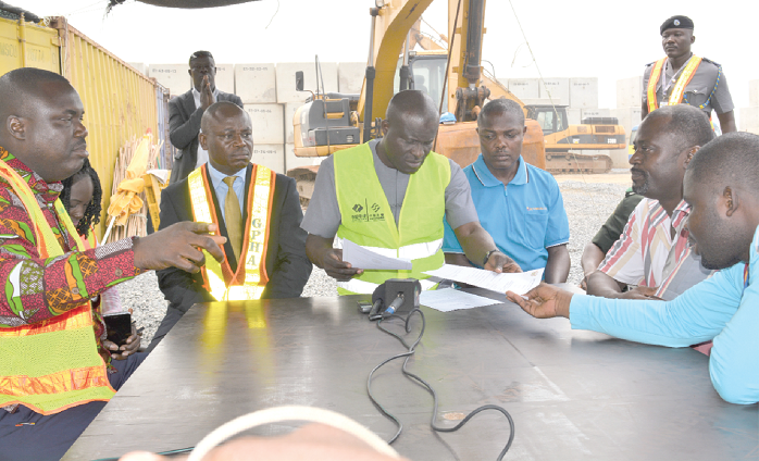 Mr Titus-Glover (middle) and the team scrutinising some documents presented by owners of the facility