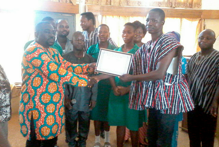 •  Mr Peter Ayamga (left) handing over a certificate to Mr Timothy Atanga, a teacher at Azeem-Namoa Senior High Technical School which won the debate