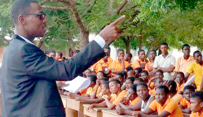 Mr Boateng (left) speaking to students about good sanitation practices