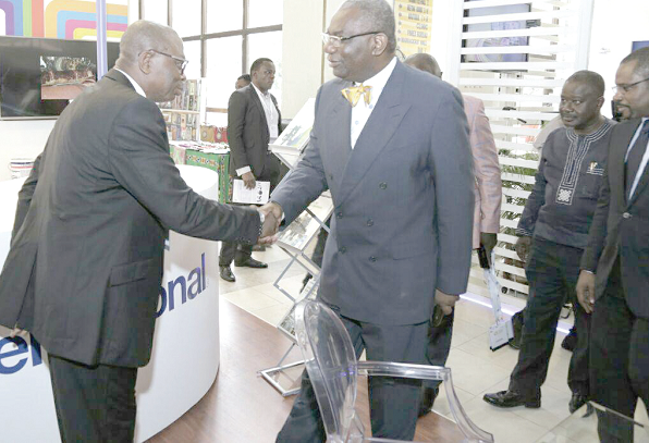 Mr Bonarh Sarpong (left), General Manager of M&K Gh Ltd, welcoming Mr Boakye Agarko, the Minister of Energy, to the International Paint, stand during the Oil and Gas exhibition  at the AICC in Accra