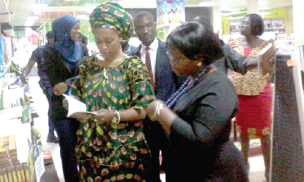 Mrs Barbara Asher Ayisi (left) being conducted round the EPP Books Service Ltd by Ms Millicent Brookman Amissah, General Manager of the company, during the visit. With them are some staff members of the company and officials from the ministry