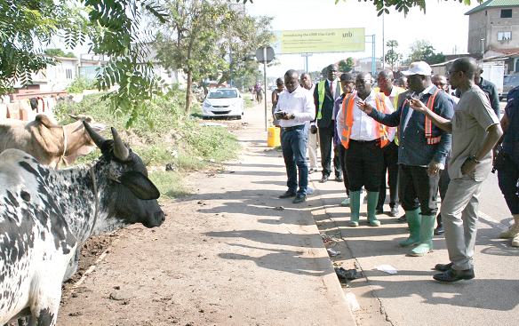 Mr Amoako-Attah, the Minister of Roads and Highways, pointing at some of the rubbish dumped along the  Kanda Highway