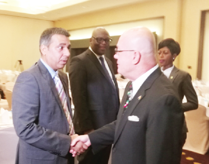 Mr Robert Jackson (right), the US Ambassador to Ghana, in a chat with a participant after the launch of the report. In the middle is Mr Simon Madjie, Executive Secretary of AMCHAM.