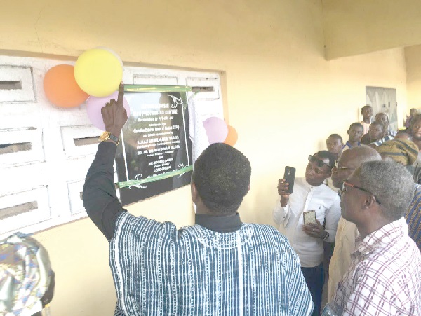 • Rev. Dr Solomon Sule-Saa (left in smock) being assisted by Mr George Baiden to unveil a plaque to inaugurate the rice processing centre