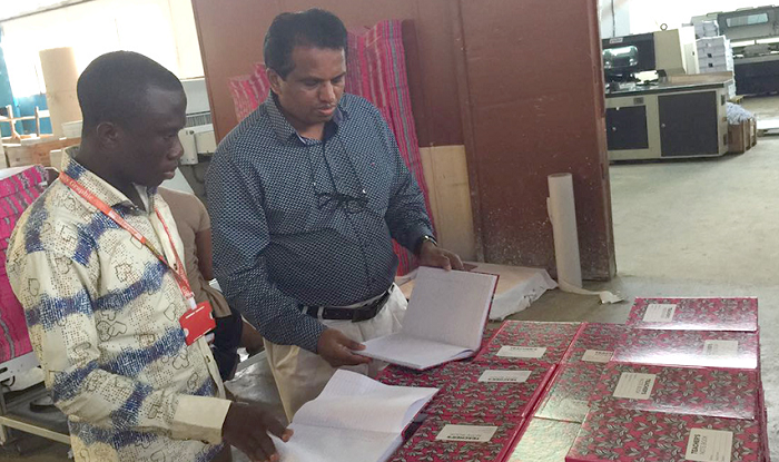  Mr Thampi (right) taking our reporter through the differences  between locally manufactured exercise books and imported ones