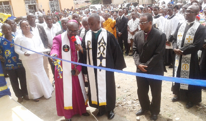 Rt Rev. Andam (holding scissors) cutting the tape to inuagurate the new manse (inset) at Oforikrom in Kumasi while Rev. Osei Karikari (right) and others look on