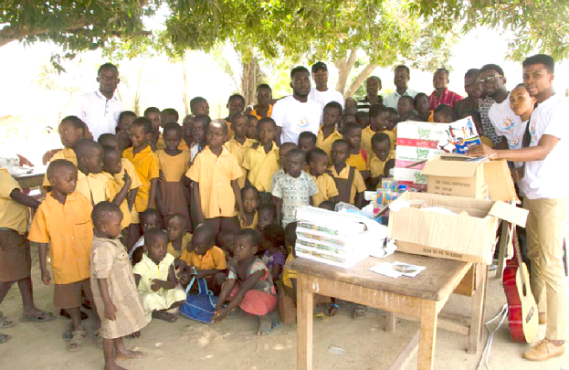 Members of the Searchlight Africa Foundation in a group photograph with pupils of the Nipanekro D/A Primary School