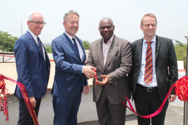  Mr Boakye Agyarko (2nd right),  cutting a tape to launch the Solar PV system, with him are Mr Christoph Retzlaff (2nd left), and Mr Alan Walsch. Picture: INNOCENT K. OWUSU.