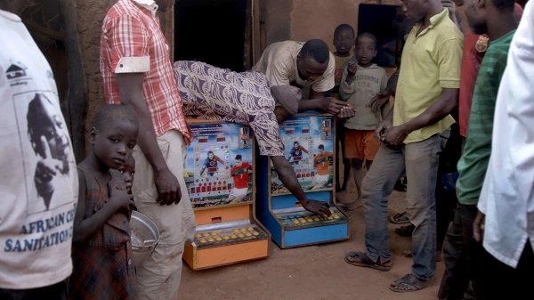 Villagers bring two gambling machines out from a hut in Zamashegu, in Ghana's Northern Region