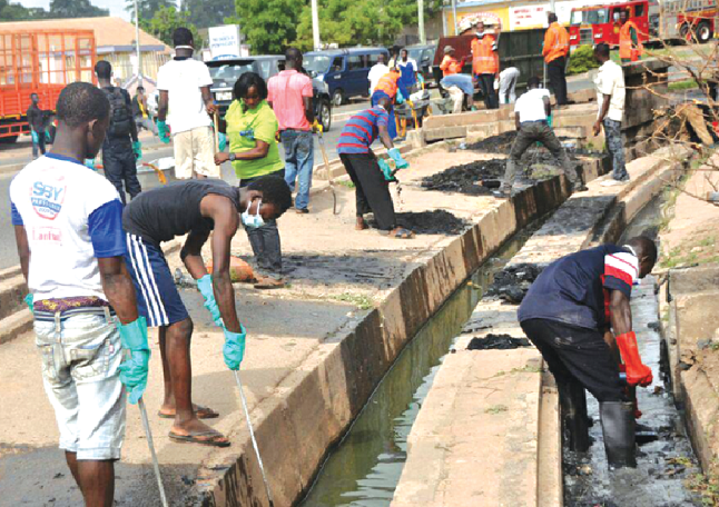 Some residents of the Manhyia Sub-metro of the Kumasi Metropolitan Assembly participating in the clean-up exercise as part of the National Sanitation Day (NSD)