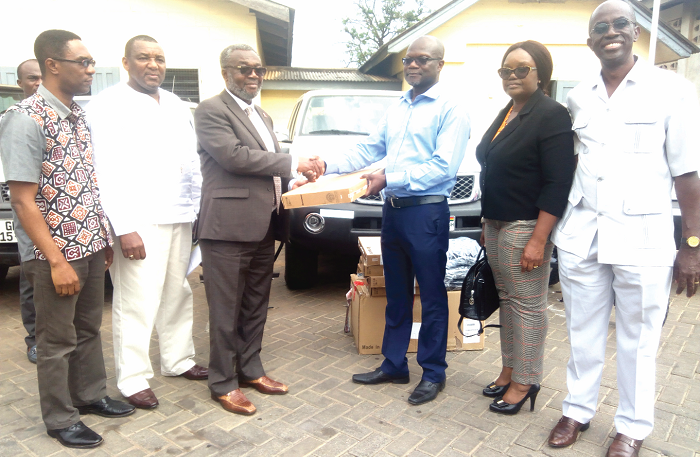 Mr Archie Laing (right) presenting the items to Dr Anthony Nsiah-Asare (left). With them are some officials of the GHS and DFID