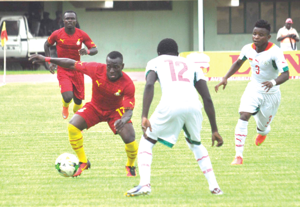 Ghana’s Patrick Razak tries to  keep the ball under control against his Burkinabe markers. Picture: OSCAR MOHAMMED Courtesy: Adonko Bitters