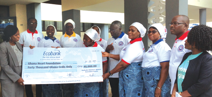 Mrs Anna Awotwi Pratt presenting a cheque to Ms Anastasia Himans, the Administrator of the Ghana Heart Foundation. Looking on are some executives of the association