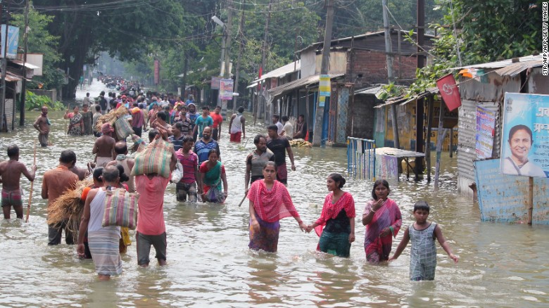 Residents wade through flood waters in the Indian state of West Bengal on August 17.