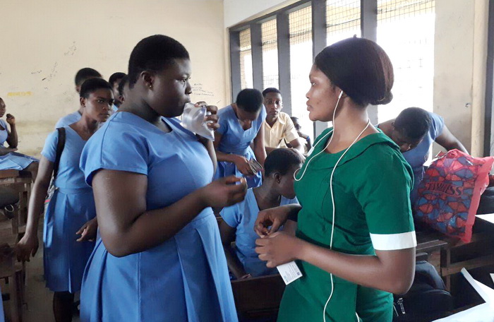 A nurse administering medication to one of the students of Kumasi Academy
