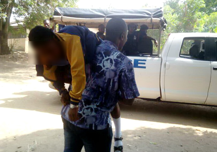 The first student who collapsed on Tuesday being conveyed by a teacher to hospital