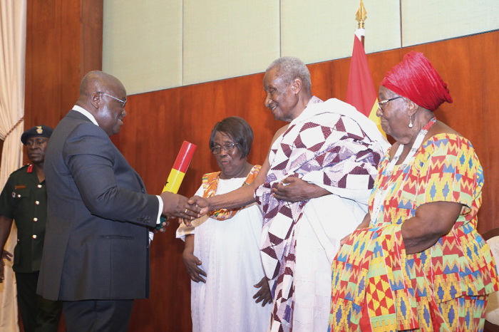 President Akufo-Addo congratulating Mr E. M. Debrah (2nd right), a former Diplomat at the Flagstaff House in Accra, after honouring him