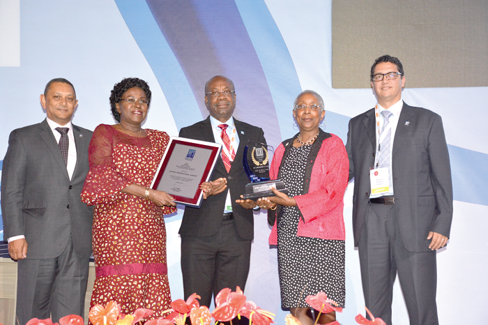 Ms Angela Gittens, Director-General of ACI, presenting the plaque to Mr John Dekyem Attafuah (middle), MD, GACL