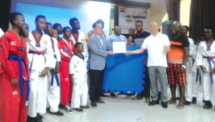 Members of the Martin Luther King Taekwondo club receiving their prizes from Mr Donqik Jeong (4nd right), Consular at the Korean Embassy 
