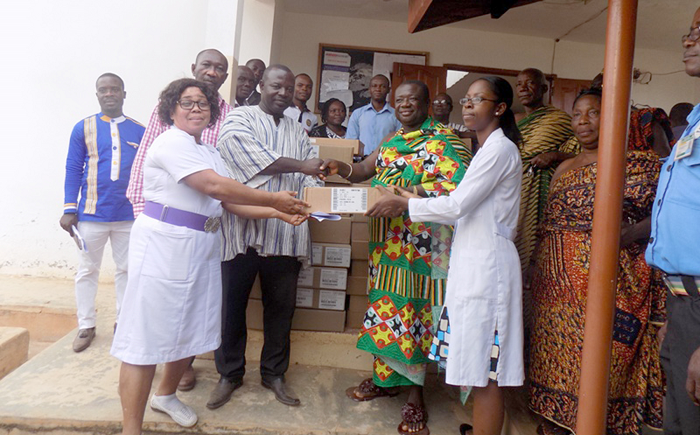  Mr Osei-Frimpong (in smock) presenting the drugs to Nana Amo Kyeretwie (in cloth), the Abiremhene, and some staff of the hospital
