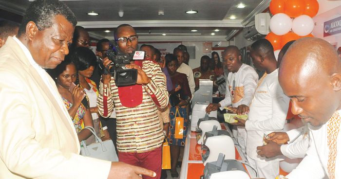  Some staff of the compan demonstrating the use of the counterffit detecting machine to Mr Emmanuel Asiedu Mantey (left), a Former Deputy Governor of Bank of Ghana. Picture: Gabriel Ahiabor