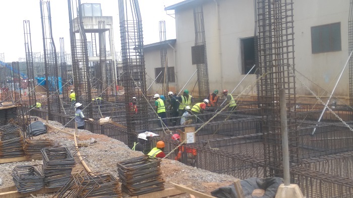Some of the workers on the site mounting pillars on one of the components