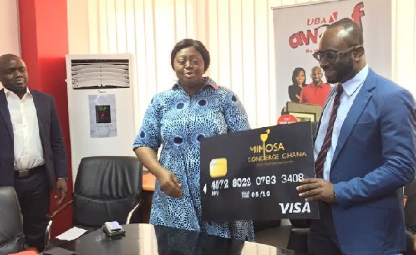Mr Chris-Samson Andoh (right) presenting the new Mimosa Visa Card to Madam Abiola Bawuah (left)