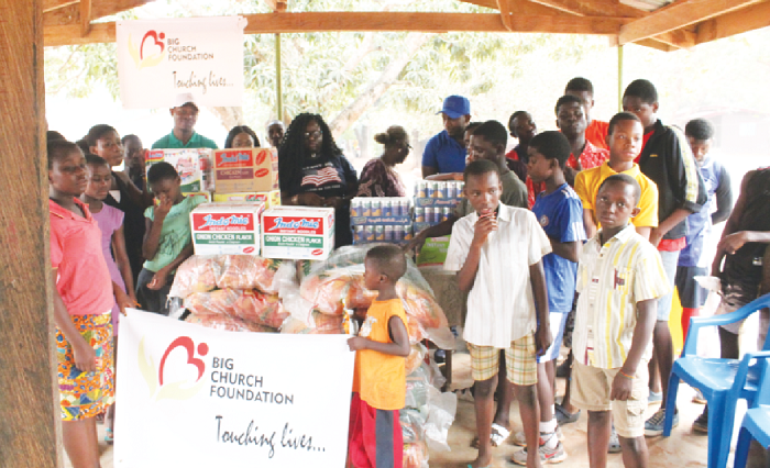  Ms Maxine Alexis surrounded by the children as she presents the items