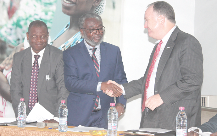 Dr Anthony Nsiah-Asare (middle), the Director General of Ghana Health Service, in a handshake with Mr Steven Hendrix (right), Deputy Mission Director, Ghana Mission of USAID Ghana. Looking on is Dr Patrick Kuma-Aboagye (left), a Director of Family Health Division at Ghana Health Service