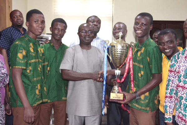 Mr Osei Assibey (middle) with the three students, Kofi  Konadu, Sarfo-Ansah Wonder and Osei Daniel, who won the trophy for the school, the headmaster and a  staff member of the school