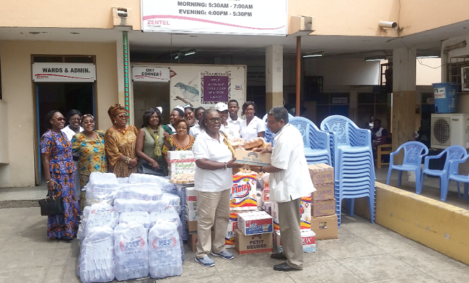 Mrs Grace Asante, President of FAWA (left), presenting the items to Dr Isaac Abban, a Paediatrician (right), on behalf of PML Hospital as members of FAWA look on. 